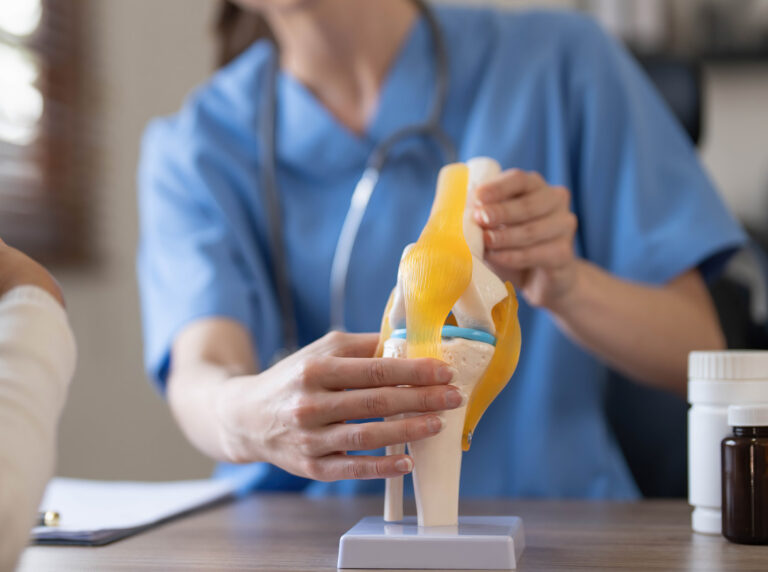 Fotografia przedstawia rekonstrukcję więzadła – zaawansowany zabieg chirurgiczny wykonywany w celu przywrócenia stabilności i funkcji uszkodzonego stawu. Na zdjęciu widoczny jest chirurg w trakcie precyzyjnego operowania stawu kolanowego z użyciem specjalistycznych narzędzi. Sterylne otoczenie sali operacyjnej oraz ekran monitorujący przebieg zabiegu podkreślają profesjonalizm i zaawansowaną technologię stosowaną w trakcie operacji.